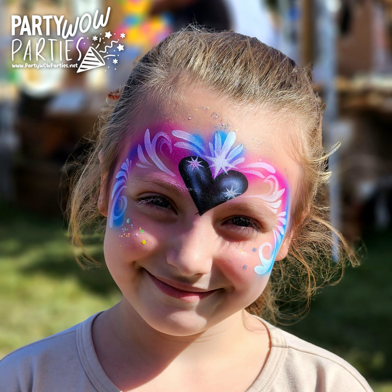 Smiling young girl shows off her airbrush princess face paint design created by an artist at Party WOW Parties in Maryville Tennessee